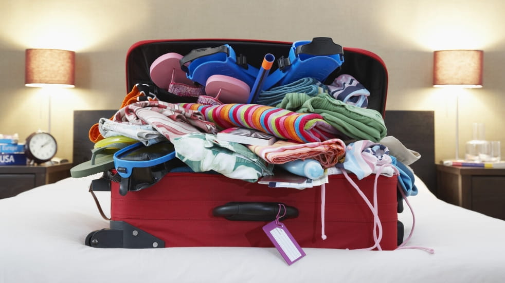 Open suitcase on hotel bed